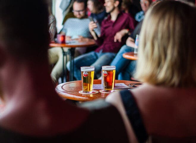 People sitting at tables talking and watching a show