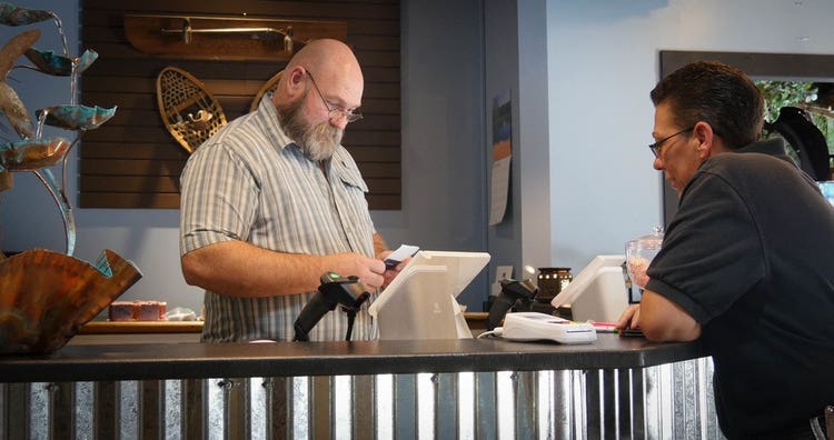 Cashier ringing up a customer on Clover Station