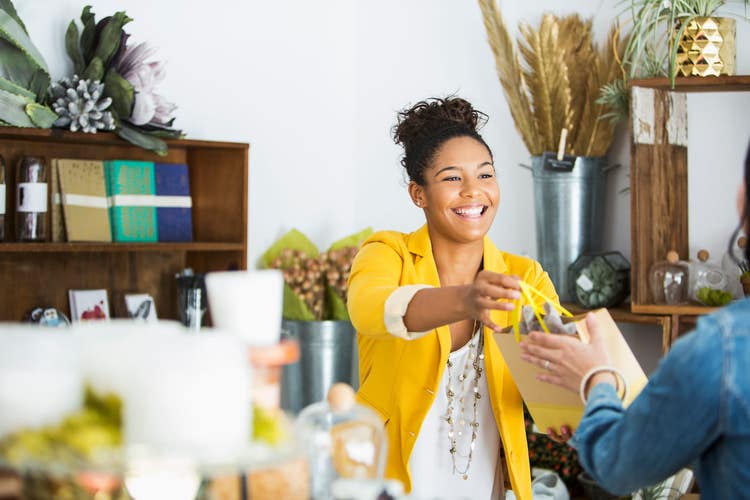 Merchant handing purchased item to customer
