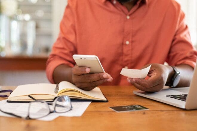Person holding phone looking at receipt