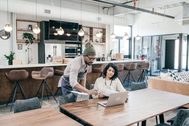 Coffee shop workers looking at laptop