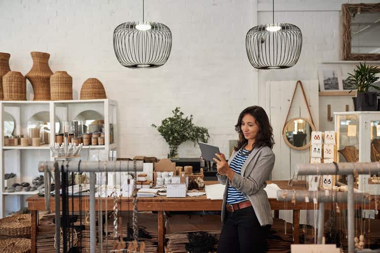 Woman looking at tablet in boutique