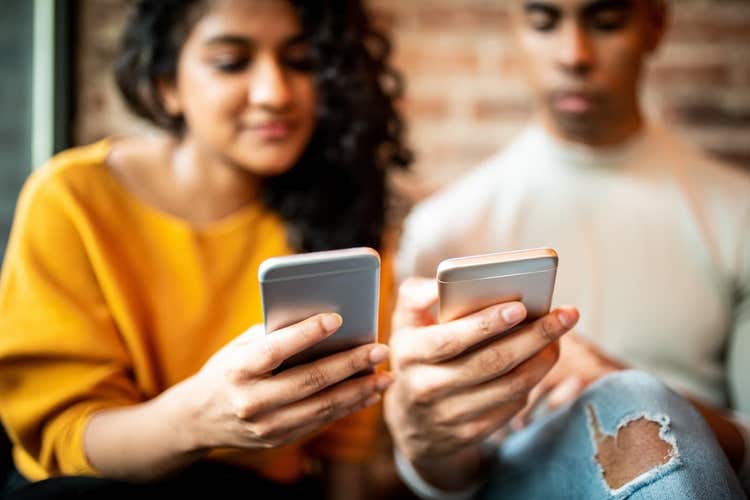 Two people looking at smartphones