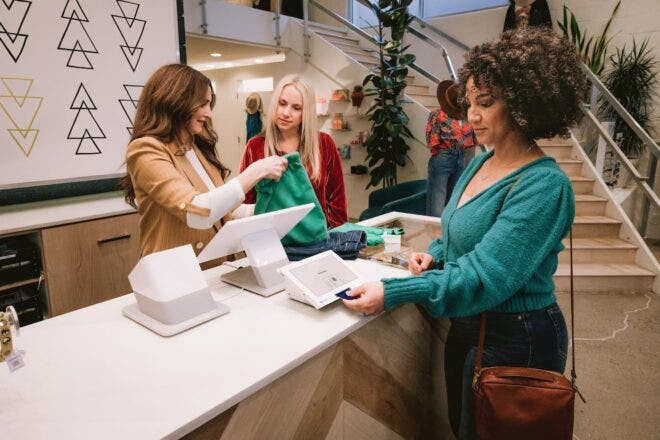 Retail employees checking out customers at Station Duo