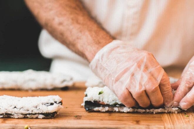 Hands rolling sushi