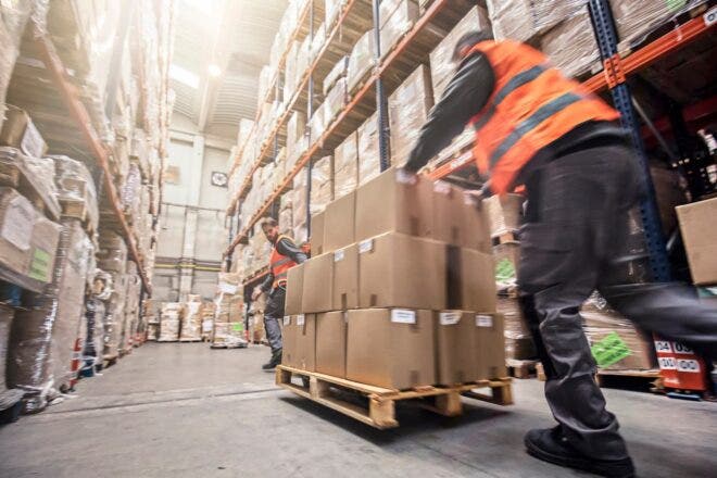 Men moving a pallet of boxes in a warehouse