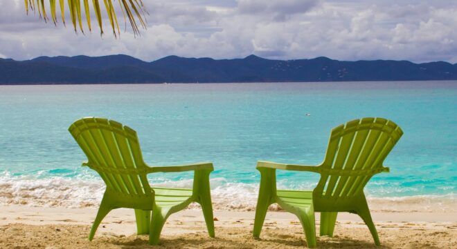 Green adirondack chairs on beach