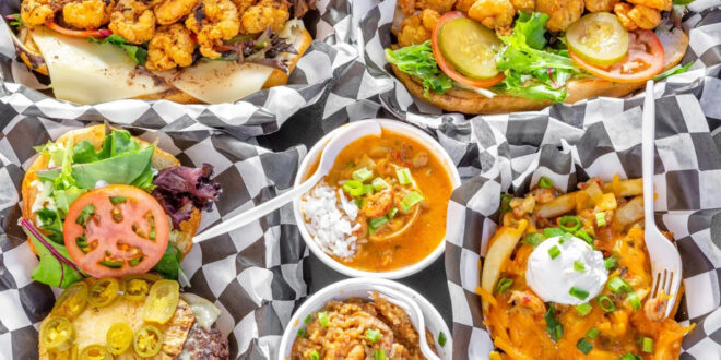 Close up of food that's local to New Orleans, like a shrimp po'boy, gumbo, crawfish fries, and a hamburger.