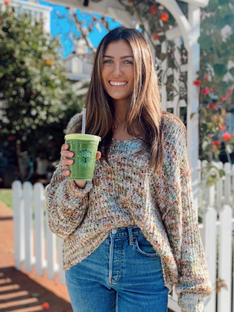 Woman holding smoothie from Thrive Juice Lab
