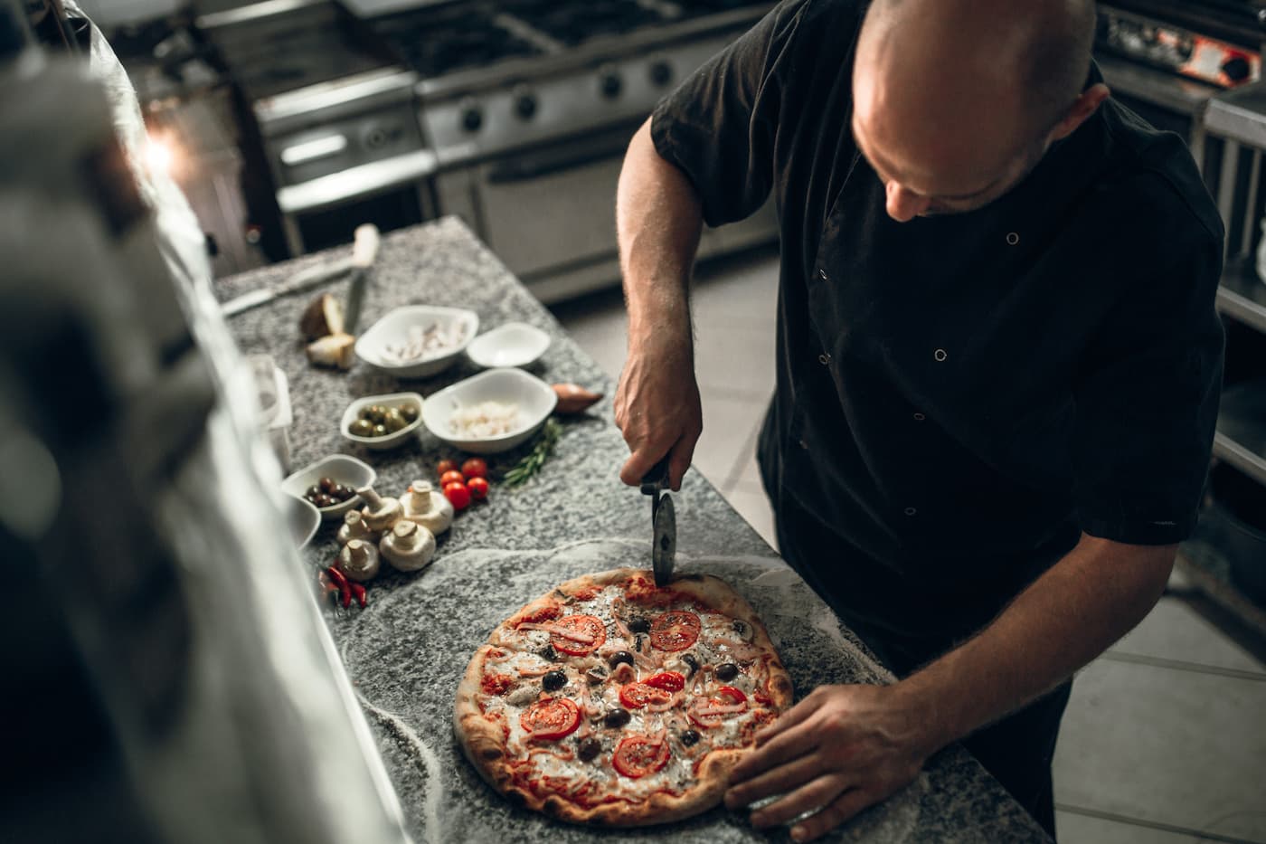 Chef cutting a pizza