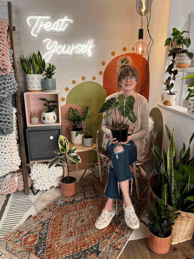 Jennifer DeLorenzo holding a plant in her shop