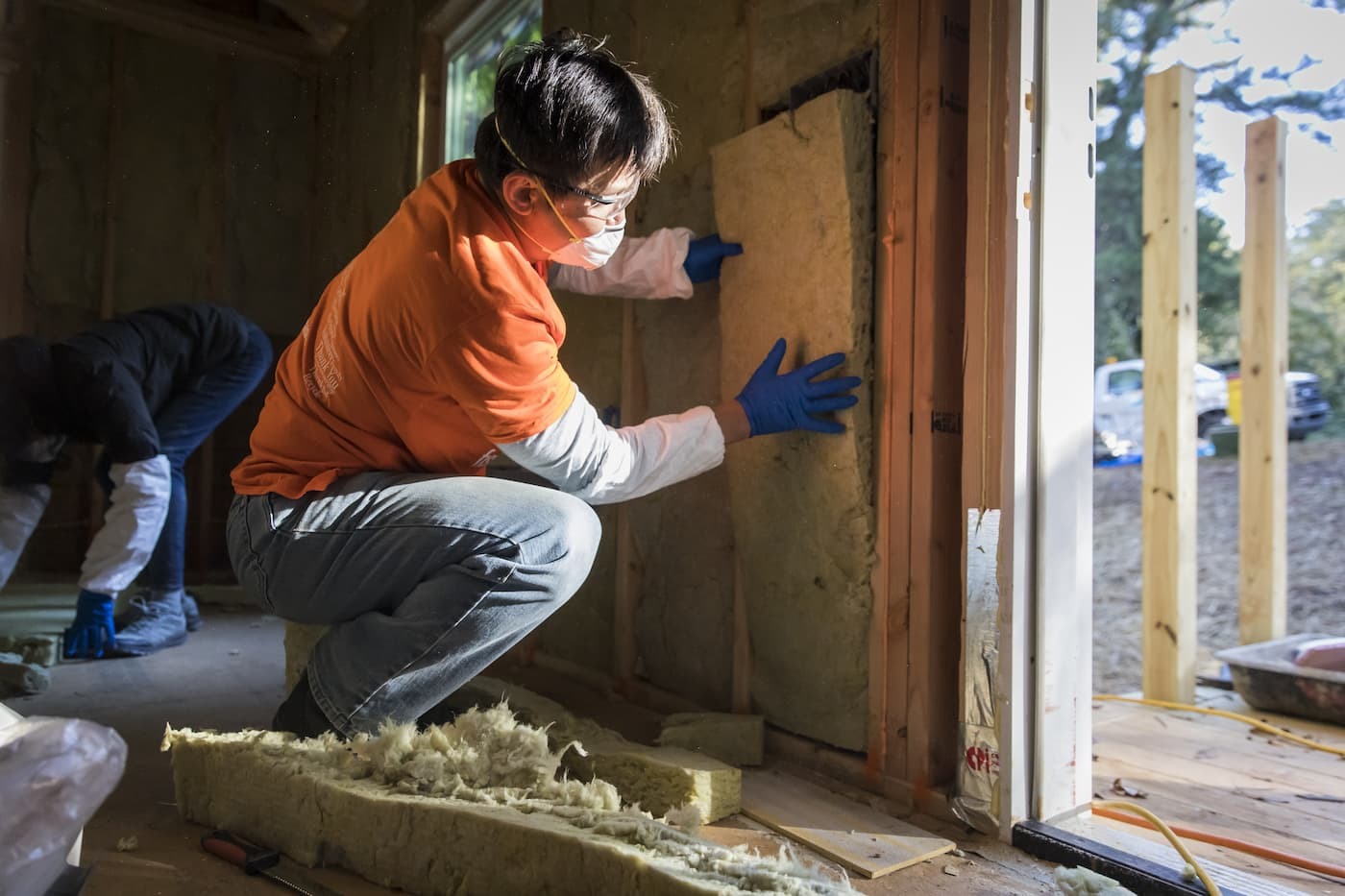 Man installing insulation in wall