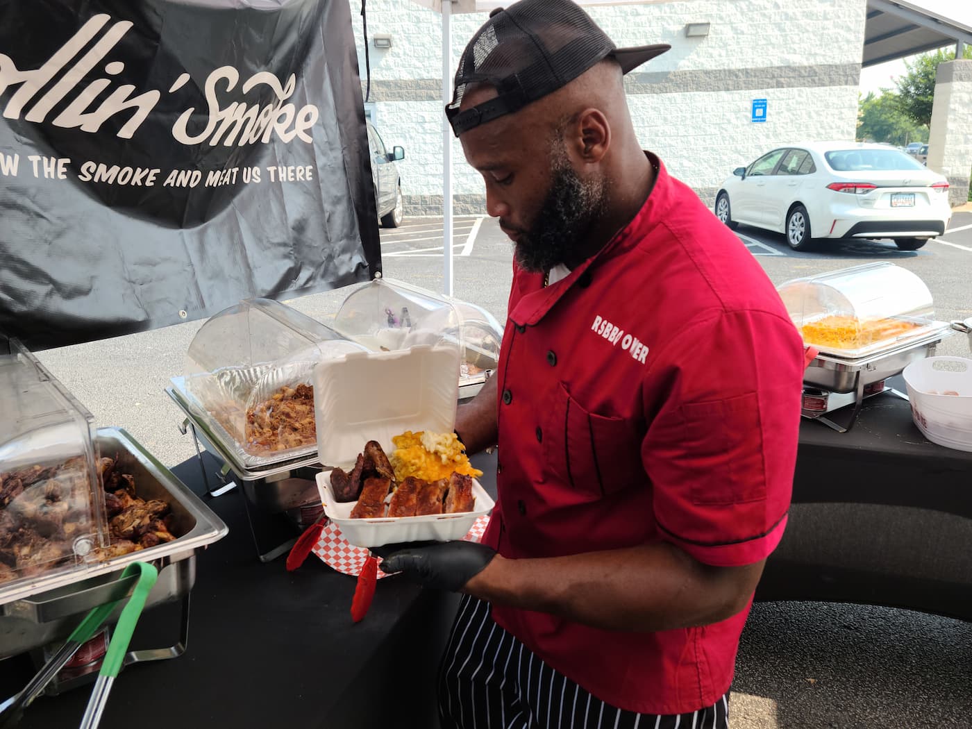 Rollin' Smoke BBQ owner with ribs and mac and cheese