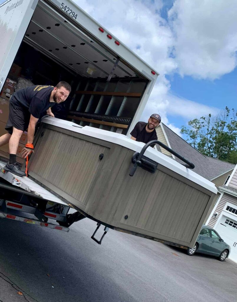 Movers moving a jacuzzi off truck