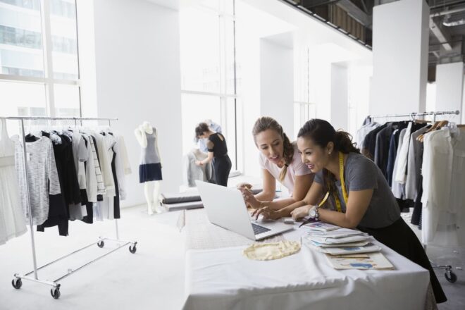 Two women designing clothes in studio