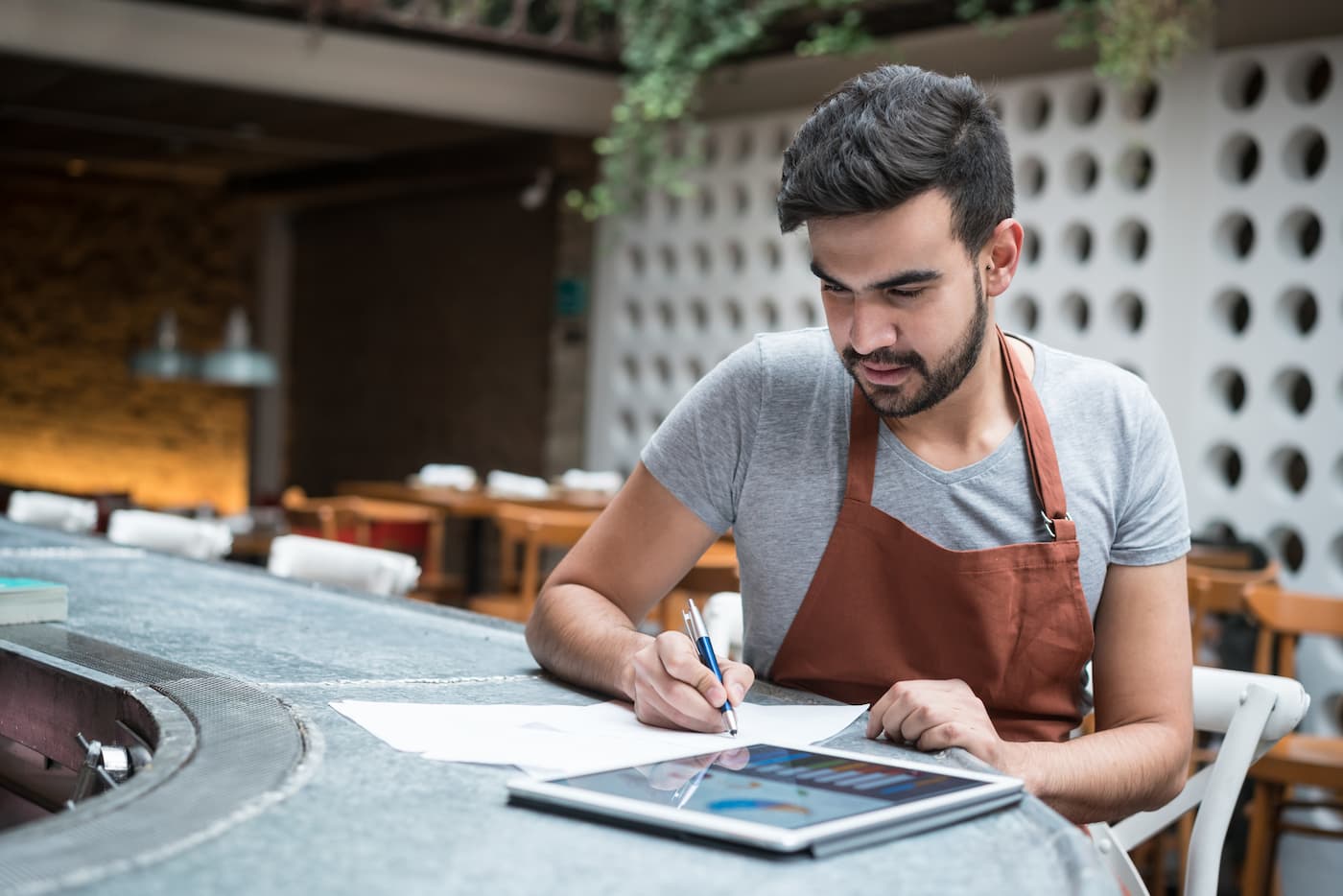 Restaurant owner looking at accounting software on tablet