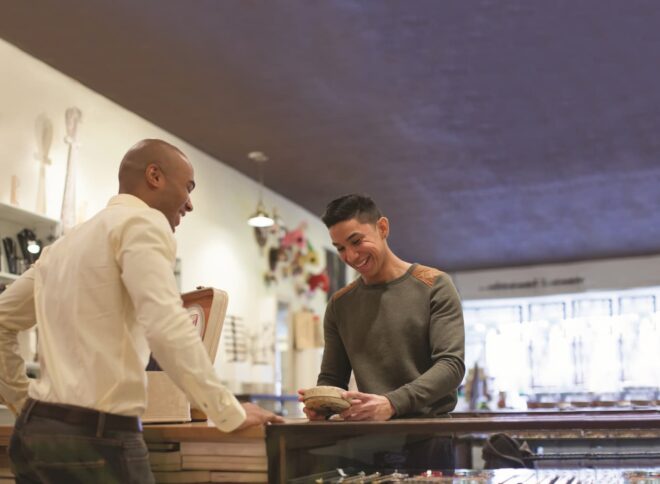 Man making purchase from jewelry shop merchant