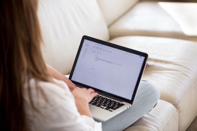Woman typing email on laptop