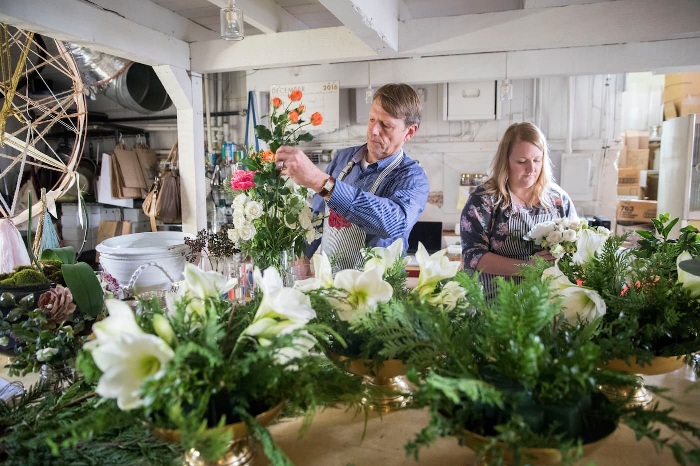 Two people making floral arrangements