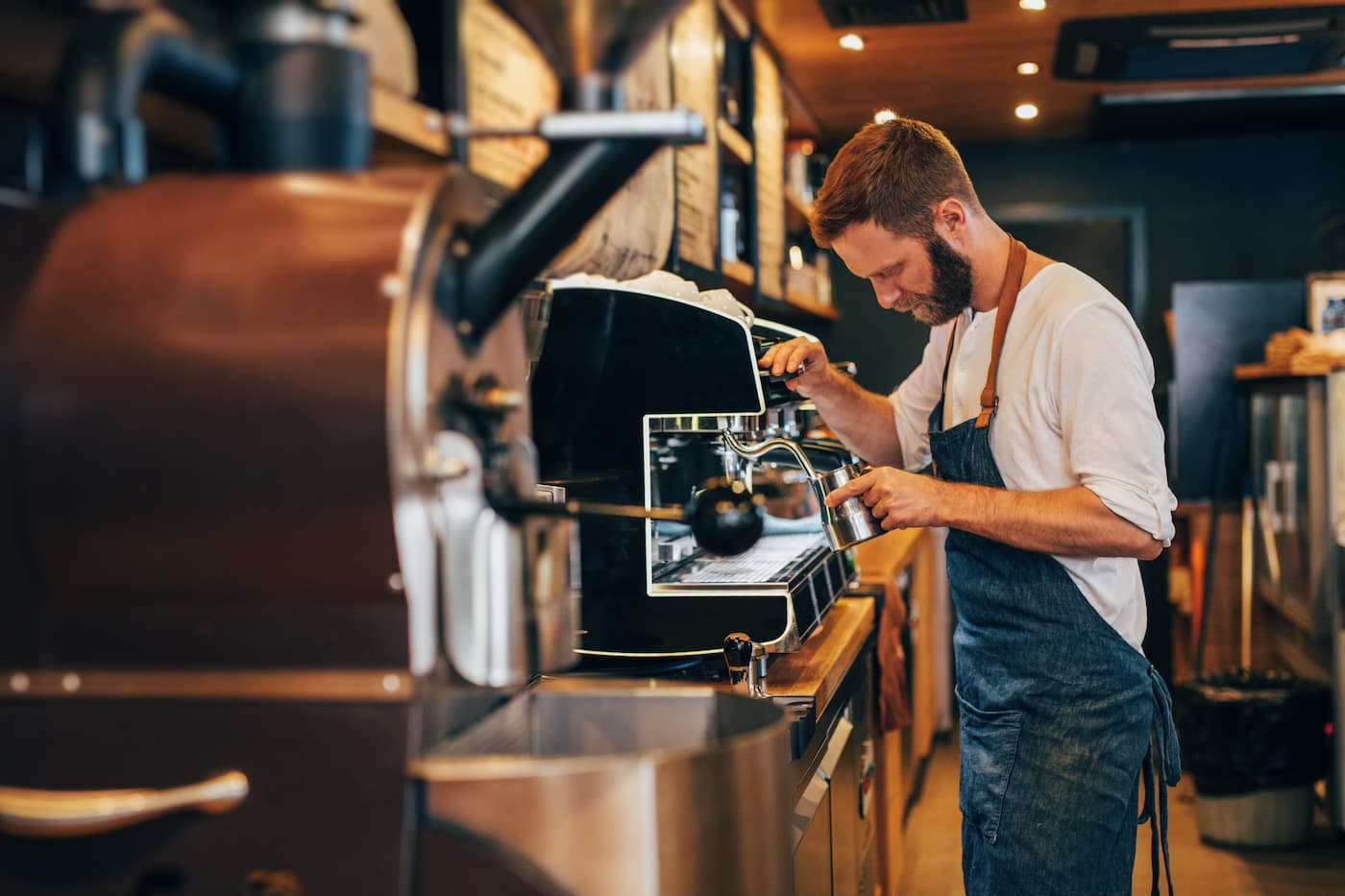 Barista making a latte with café equipment
