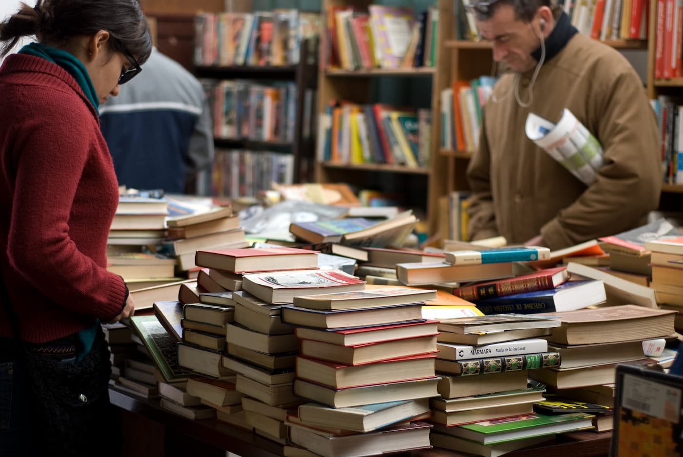 People sorting through books at bookstore
