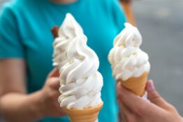 Three soft serve vanilla ice cream cones