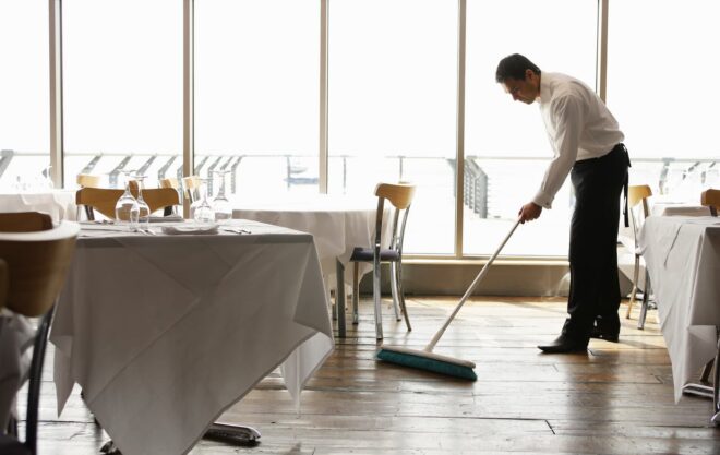Restaurant employee sweeping the floor
