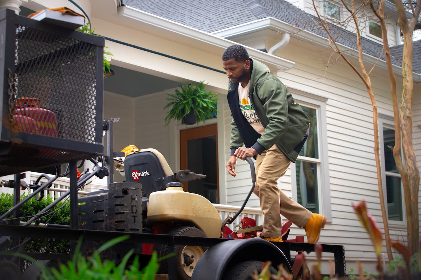 Landscaper unloading riding lawn mower