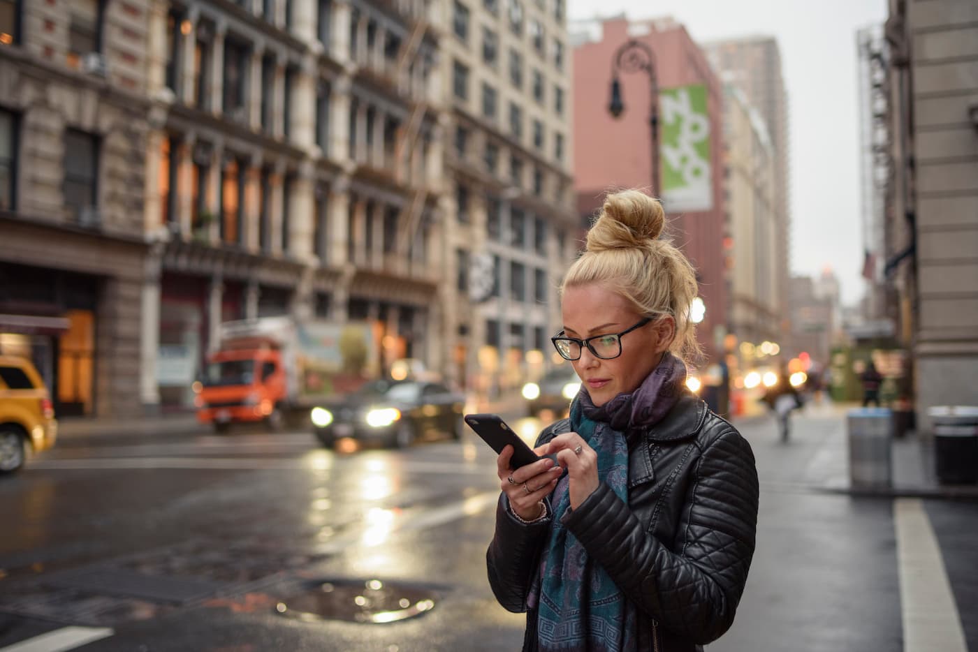 Woman checking text messages on city street