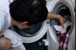 Person grabbing clothes out of washing machine