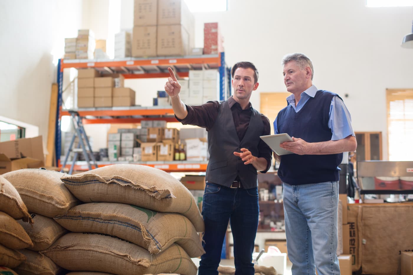 Two men discussing in stock room or storage space