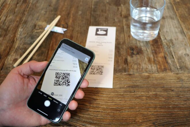 Smartphone scanning QR code to pay at sushi restaurant