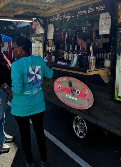 Customers standing in front of Sweet Vine Products trailer at a street festival
