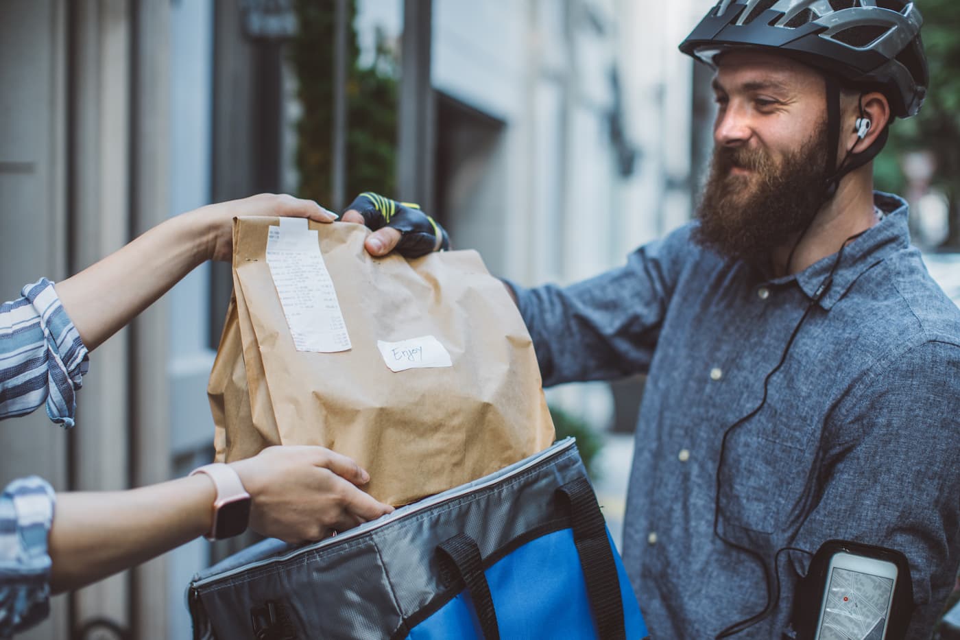Food delivery man handing over brown bag