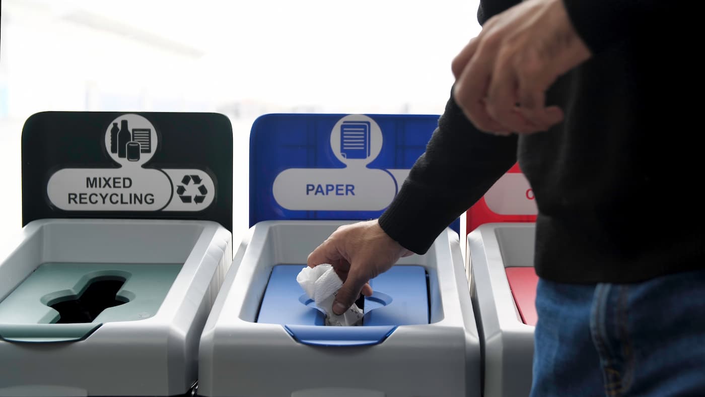 Person placing paper in recycling bin