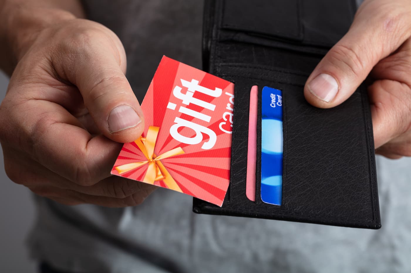 Person putting gift card in wallet