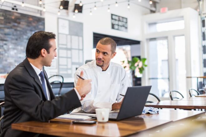 Business man explaining with male chef