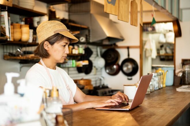 restaurant owner behind counter with laptop