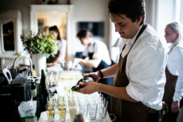 Restaurant server pouring champagne into glasses at an event