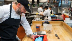 chef in restaurant kitchen reviewing inventory on tablet