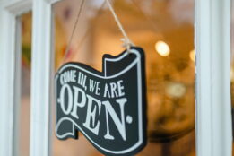 Open sign on front door of a shop