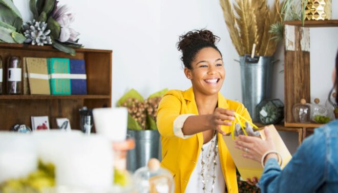 retail employee giving packaged purchase to loyal customer