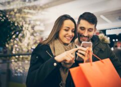 couple using phone while holiday shopping