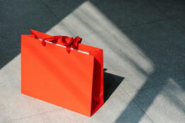 Orange gift bag sitting on a concrete floor in sunlight