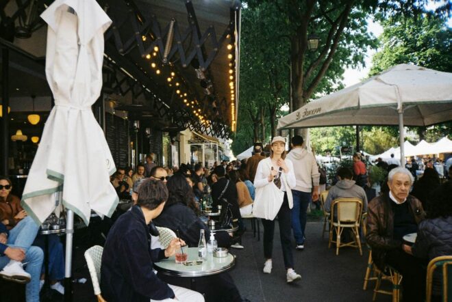 busy cafe with outdoor tables filled with customers