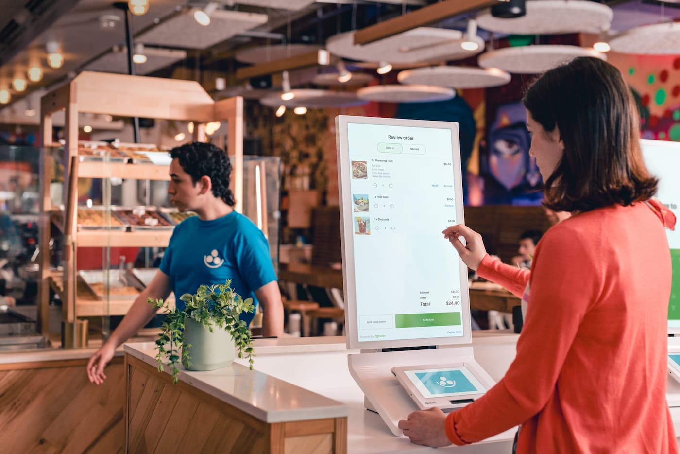 women using restaurant self ordering kiosk