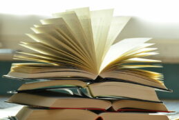 Stack of open books sitting on a desk or table