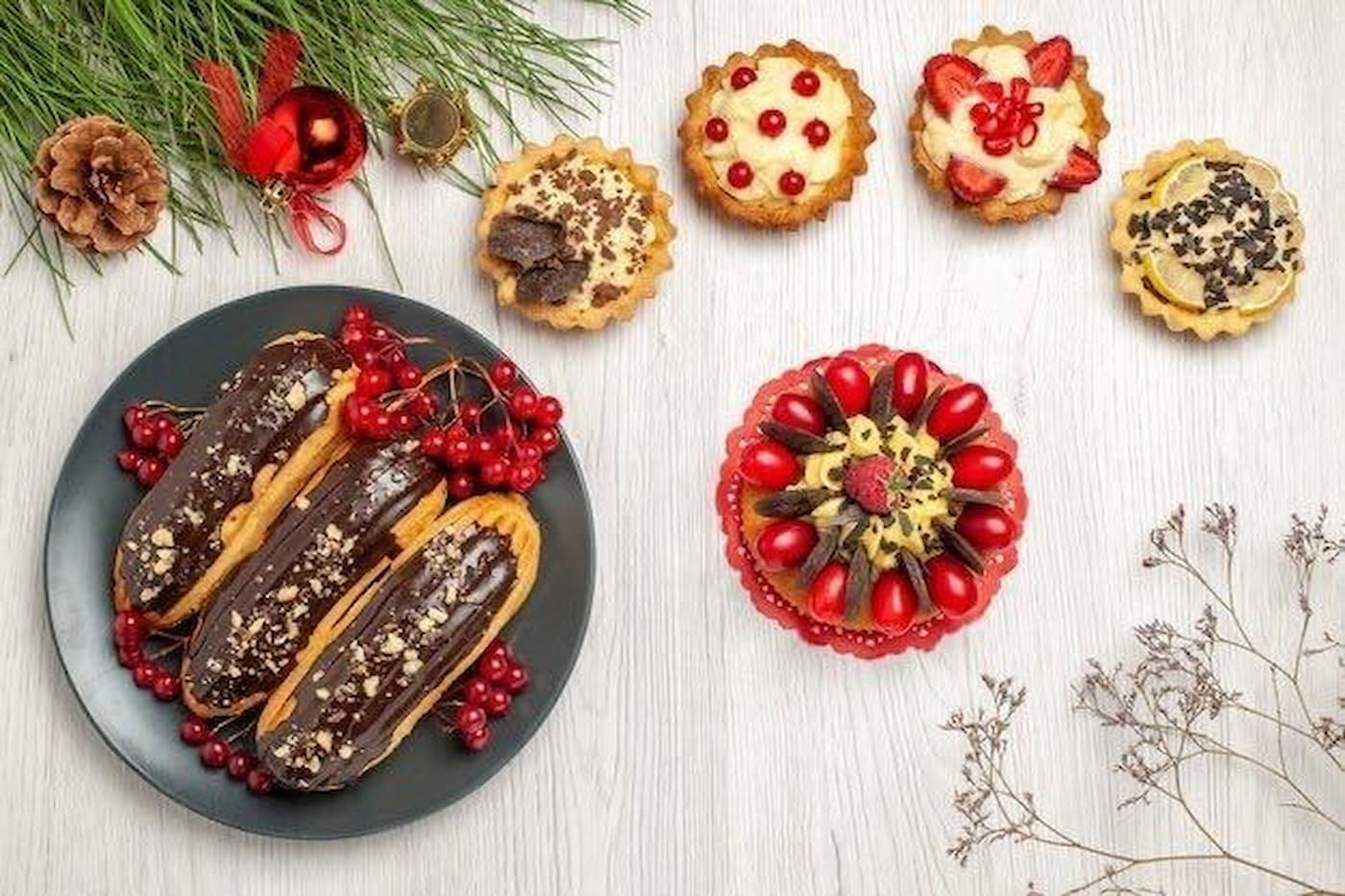 plate of holiday chocolate eclairs next to other holiday tarts and pies