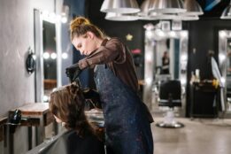 salon customer sitting in chair getting their hair cut