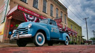 Vintage pickup truck sits in front of old-fashioned general store in Jefferson Texas